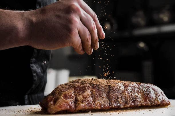 June Moon Too Tall Texan Roadhouse rub on sizzling steak at the grill