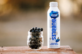 JUST Water Bubbles Huckleblueberry pour action captures a crisp, refreshing sparkling sip