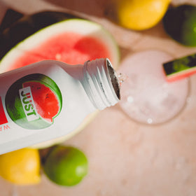 JUST Bubbles Watermelon eco-bottle in hand illustrates portable, recyclable packaging.