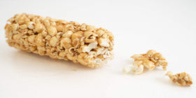 Kathy Kaye Caramel Cob popcorn bar in hand showing soft, gooey caramel.