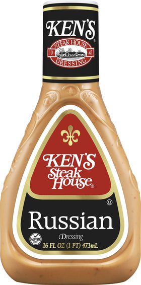 Pouring Ken's Russian Dressing over a burger for zesty flavor.
