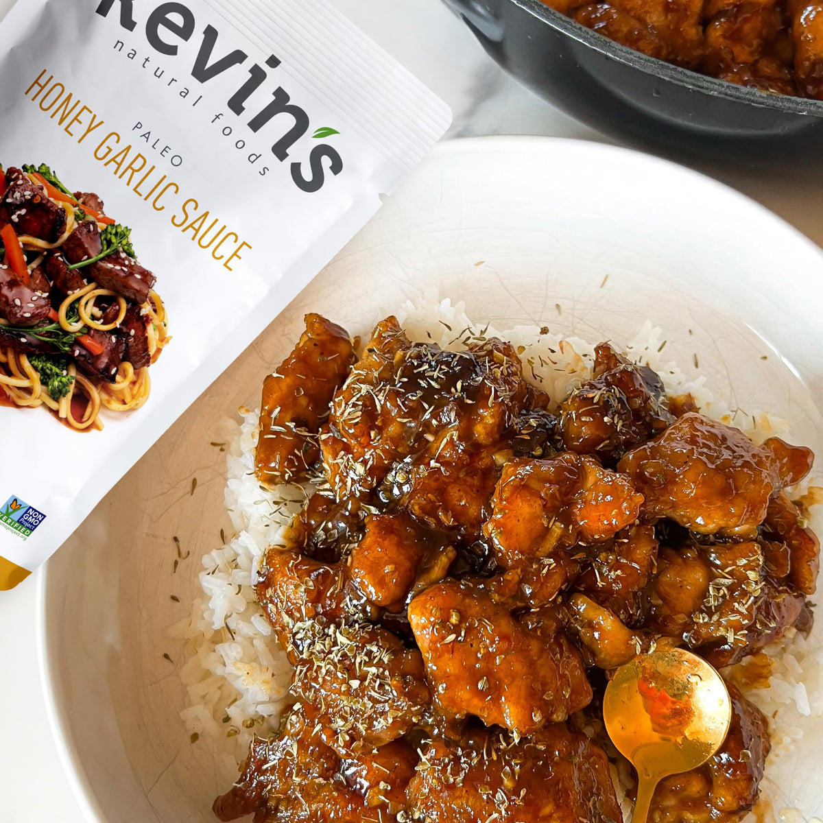 Pouring Kevin's Natural Foods Honey Garlic Sauce for a fast, flavorful stir-fry