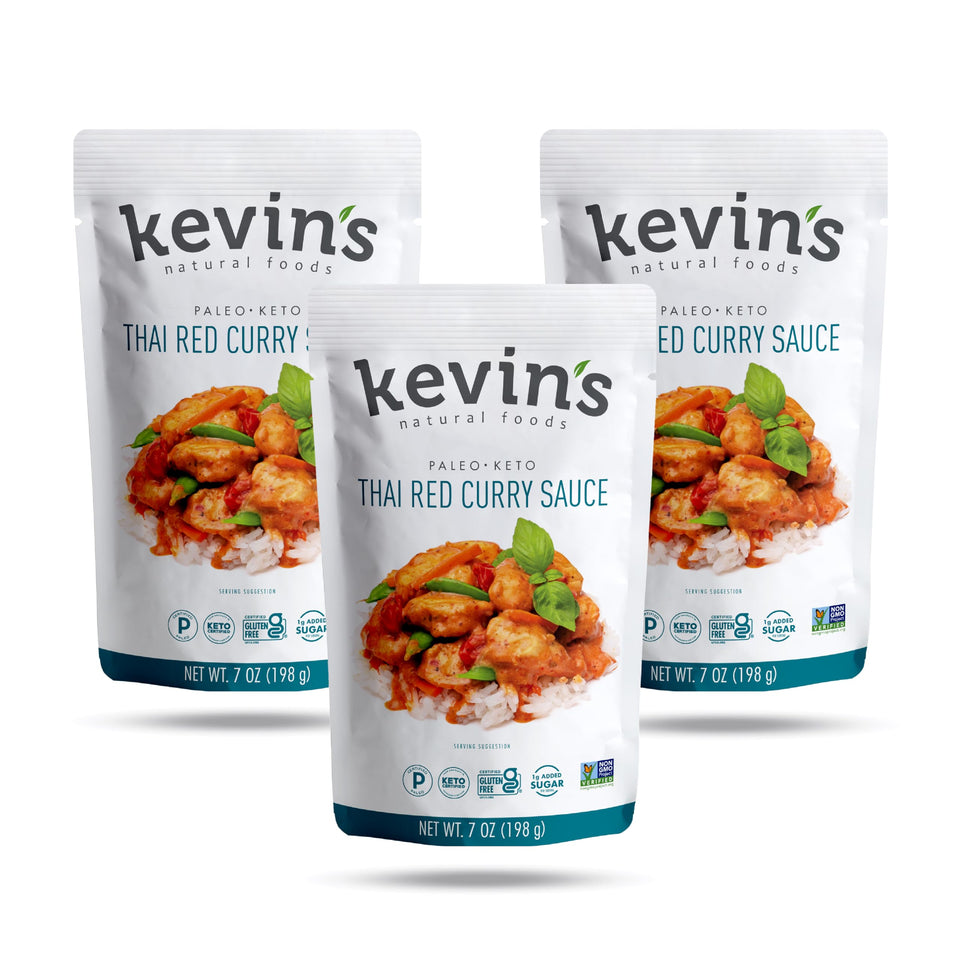 Kevin's Natural Foods Thai Red Curry Sauce bottle on stove, elevating quick gluten-free meals.