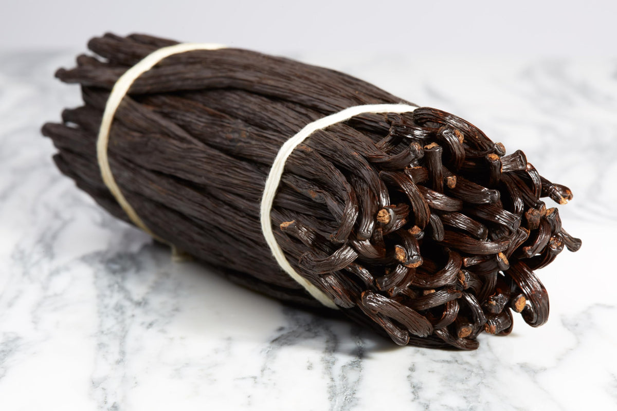 Close-up of Kiddu vanilla beans showing glossy seeds and plump pods for premium aroma.