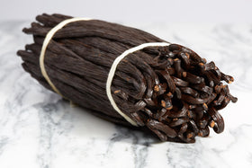 Close-up of Kiddu vanilla beans showing glossy seeds and plump pods for premium aroma.