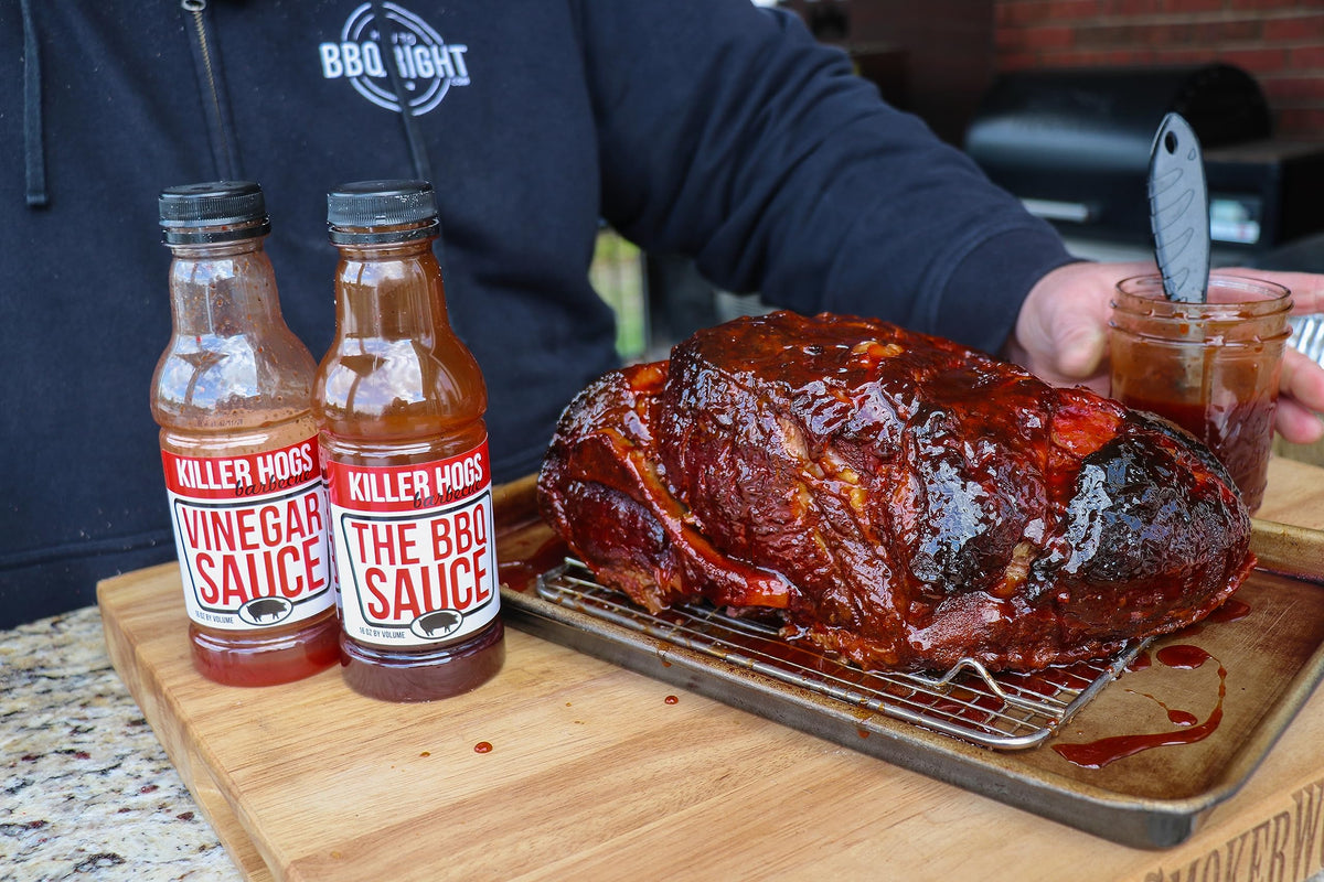 Chicken being coated with Killer Hogs BBQ sauce.