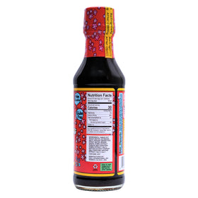 Pouring Kimono Mom UMAMI SAUCE to enhance a quick stir-fry