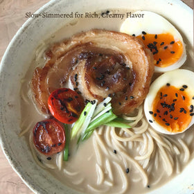 Bowl of Kitchen Kurume Tonkotsu ramen with rich, creamy broth on display.
