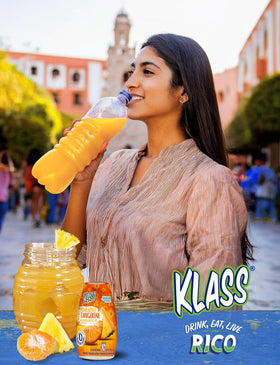 Klass Aguas Frescas Pineapple Tangerine bottle in a purse showing portable convenience.