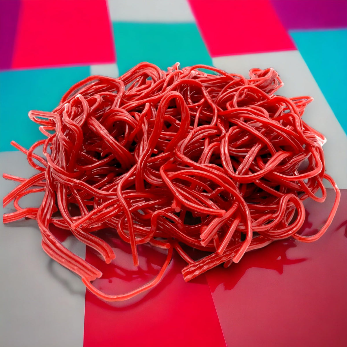KLUB BULK red strawberry licorice laces closeup showing soft, chewy texture and vivid flavor.
