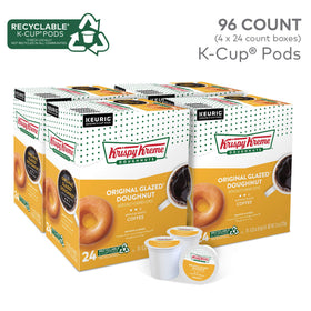 Krispy Kreme flavored medium roast coffee pods in a box beside a mug ready to brew.