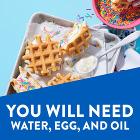 Waffles cooking on a greased Belgian waffle iron with Krusteaz mix.