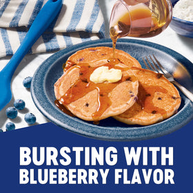 Pouring Krusteaz pancake batter onto the griddle for fluffy blueberry pancakes