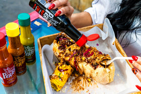 La Perrona hot sauce being poured over savory ingredients