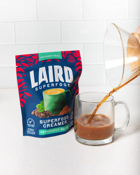 Pouring Laird Superfood peppermint mocha creamer into hot coffee