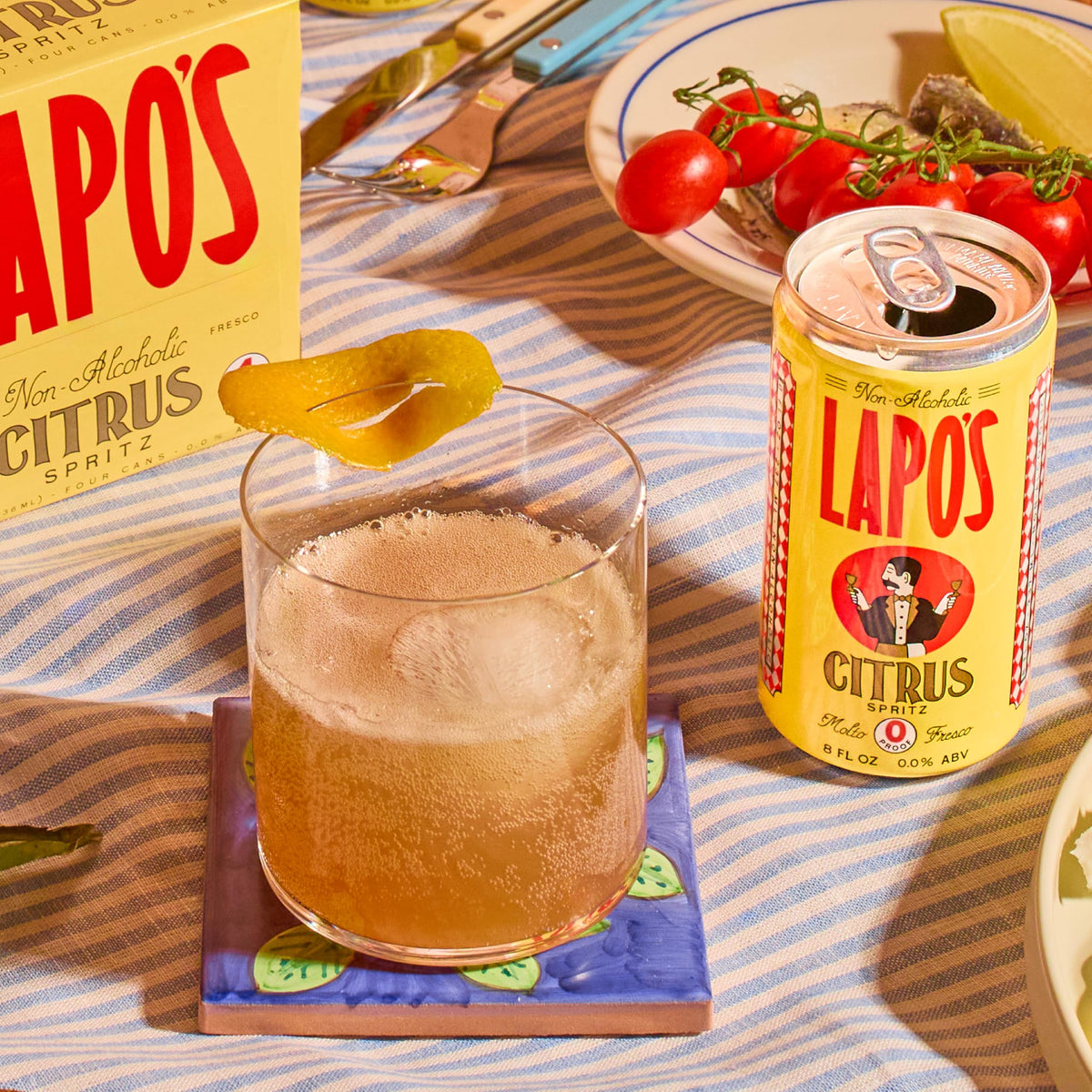 Serving setup with Lapo's Citrus Spritz cans and glasses on a table.