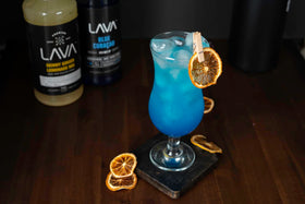 Glass with blue lagoon made using LAVA Blue Curacao Syrup.