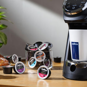 Lavazza Expert Espresso Classico capsules sitting beside a ready cup.