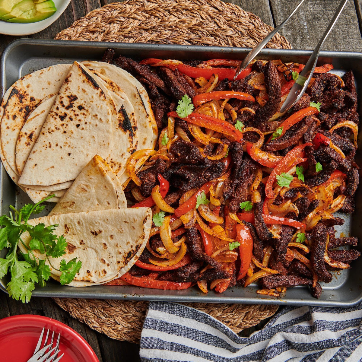 Lawry's fajitas spices with beef sizzling in pan