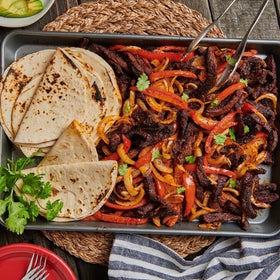Lawry's fajitas spices with beef sizzling in pan