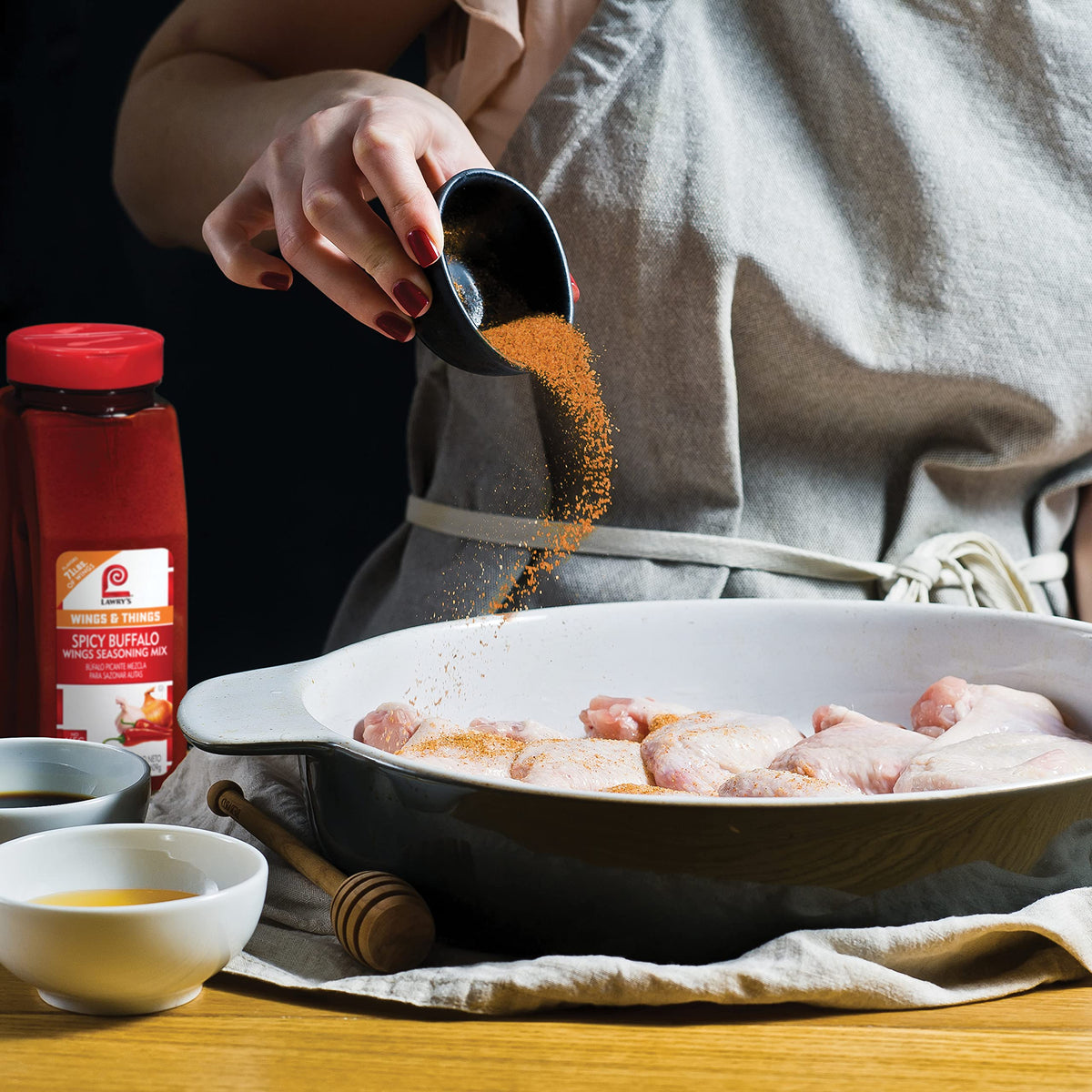 Lawry's Spicy Buffalo Wings Seasoning Mix applied to wings for crispy coating.