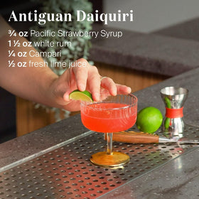 Pouring Liber & Co. Pacific Strawberry Syrup into a glass for daiquiris and margaritas.