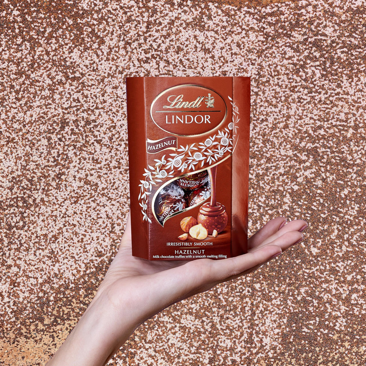 Lindt Lindor Hazelnut 200g truffle closeup, creamy center melts in the mouth.