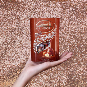 Lindt Lindor Hazelnut 200g truffle closeup, creamy center melts in the mouth.