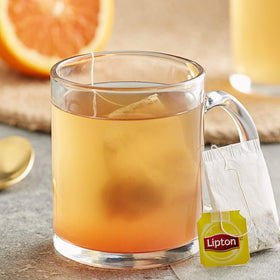 Lipton orange herbal tea cup on saucer ready to enjoy.