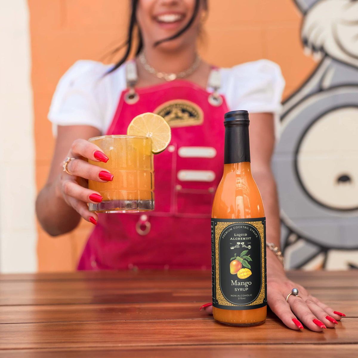 Close-up pour of Liquid Alchemist Mango Syrup for authentic taste.