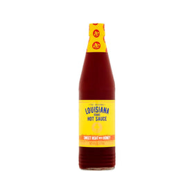 Louisiana Sweet Heat Honey Hot Sauce bottle being poured to glaze wings.