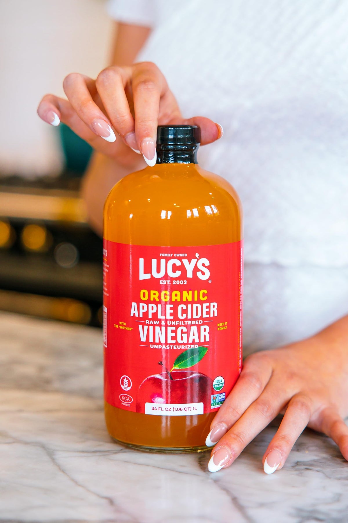 Pour shot of Lucy’s Vinegar in a clear glass bottle.