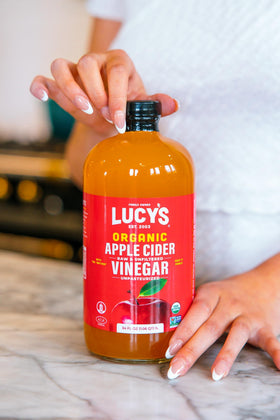 Pour shot of Lucy’s Vinegar in a clear glass bottle.