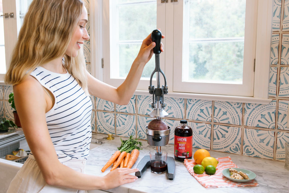 Lucy’s Organic Beet Juice clear glass bottle showcases vibrant, natural color.