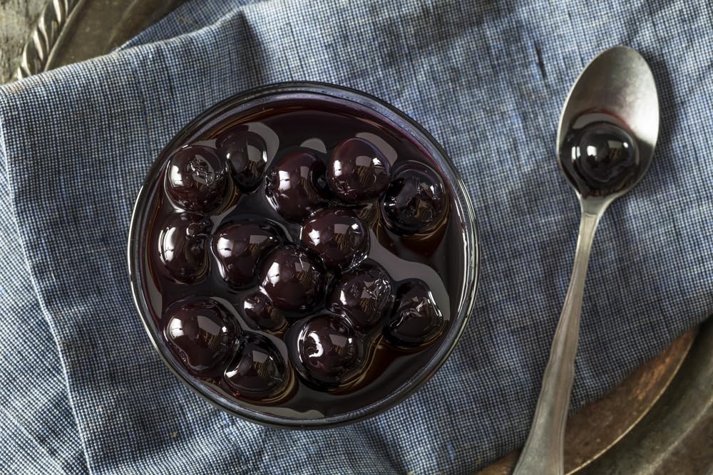 Luxardo candied cherries in syrup jar, ready for desserts and drinks.