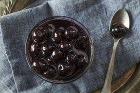 Luxardo cherries in a chef's kitchen denote professional-grade garnish and flavor.