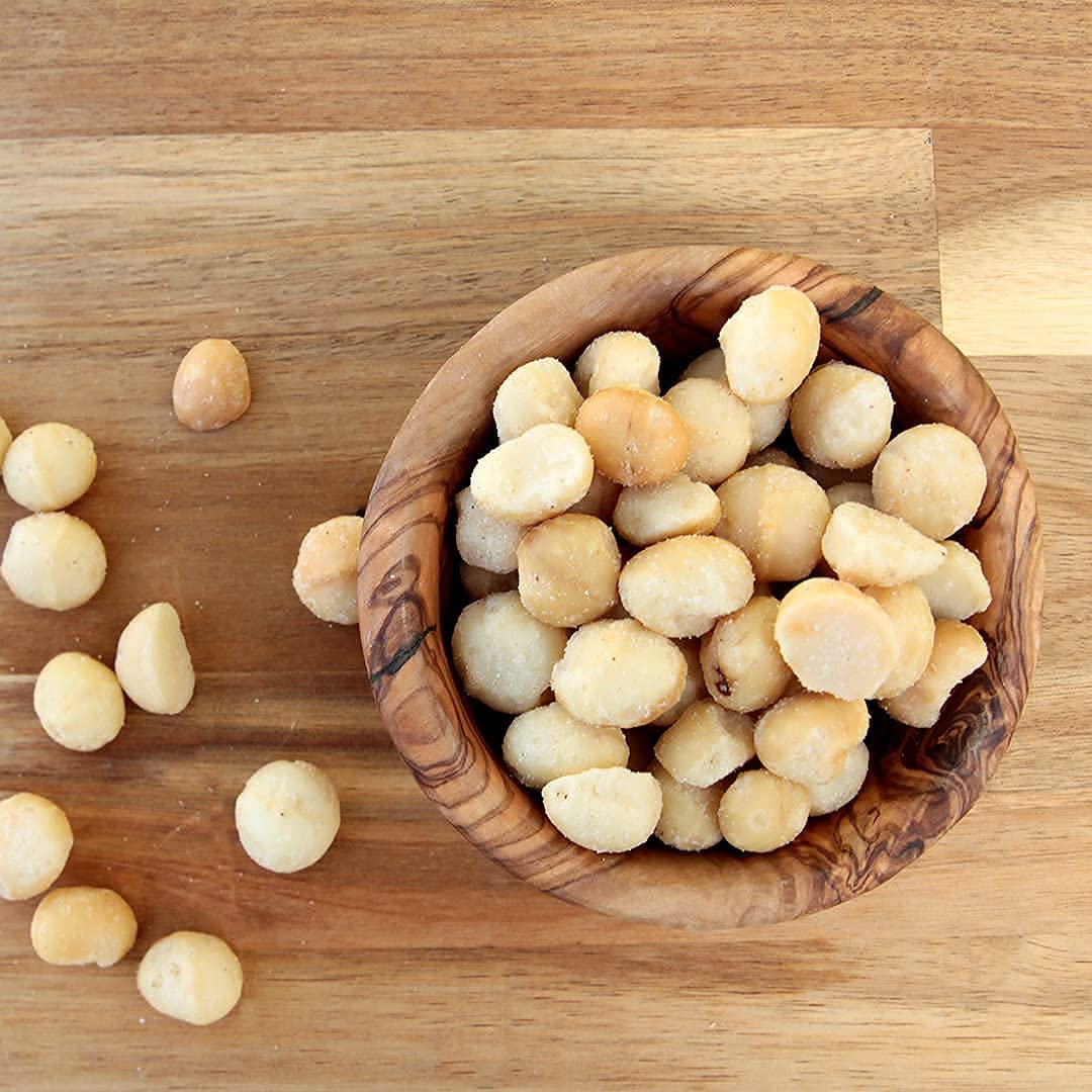 Snack plate with MacFarms macadamias and coffee cup, ideal for a quick pick-me-up.