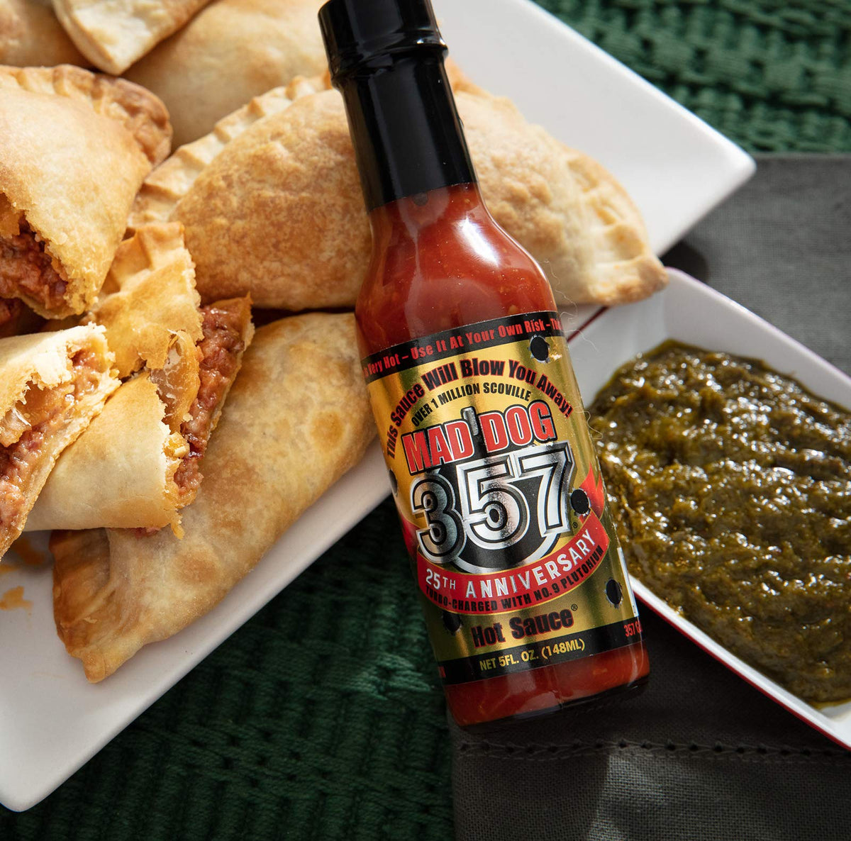 Mad Dog 357 Gold Edition sauce splash showcasing bold color and texture.