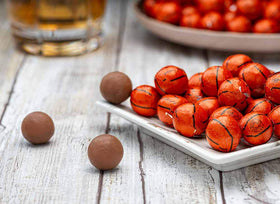 Closeup of Madelaine milk chocolate balls in foil wrap with basketball look