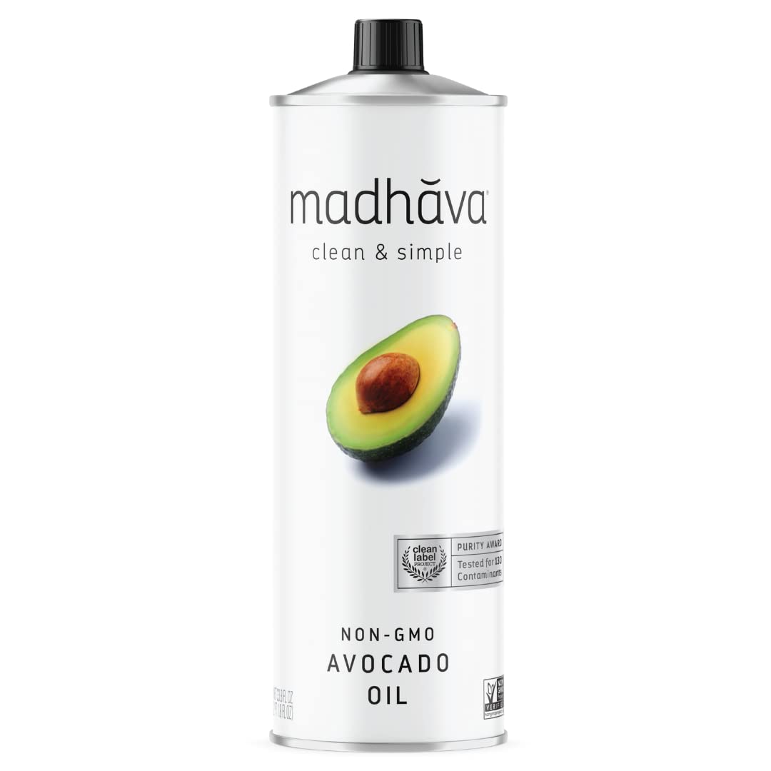MADHAVA Avocado Oil 1L tin pouring into a pan for high-heat cooking.