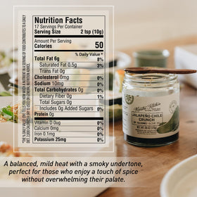 Maestro Kitchen Jalapeño Chile Crunch jar on counter with fresh ingredients.