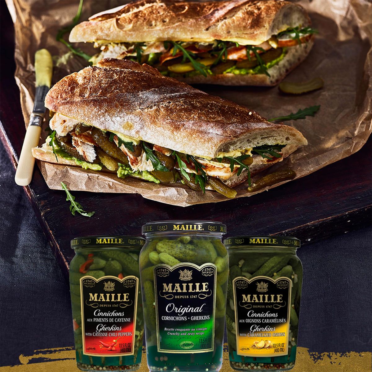 Maille Cornichons Original beside a cheese plate for snacking.