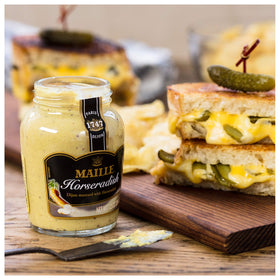 Close-up of creamy Maille Rich Country Dijon texture with brown seeds.