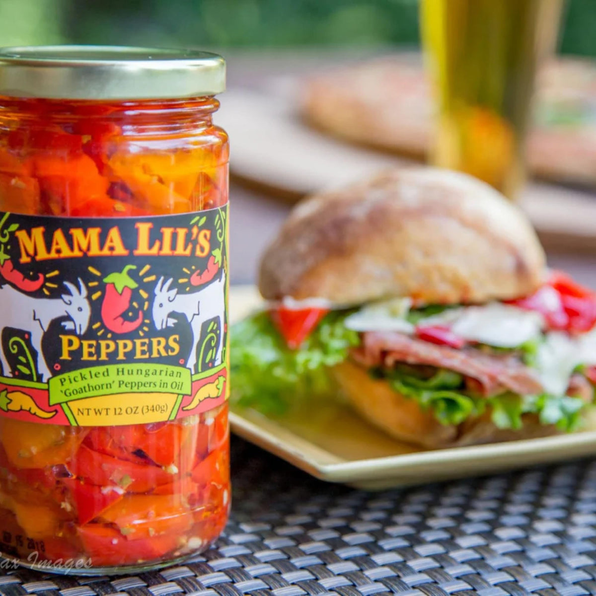 Closeup of Mama Lil's Mild Goathorn Peppers in Oil with glossy oil and pepper slices