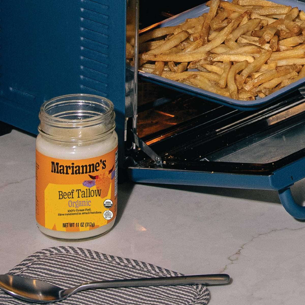 Marianne's Harvest beef tallow packaging on a kitchen shelf.