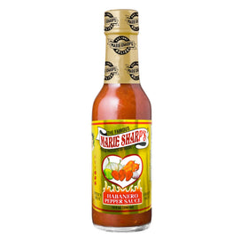 Marie Sharp's Fiery Hot Habanero sauce being poured, showcasing intense Belizean heat.