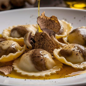 MARKY'S Italian White Truffle Oil bottle beside roasted vegetables enhances flavor.