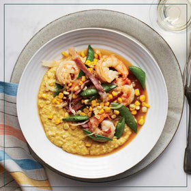 Measuring cup pours Marsh Hen Mill Sea Island Yellow Grits into a pot