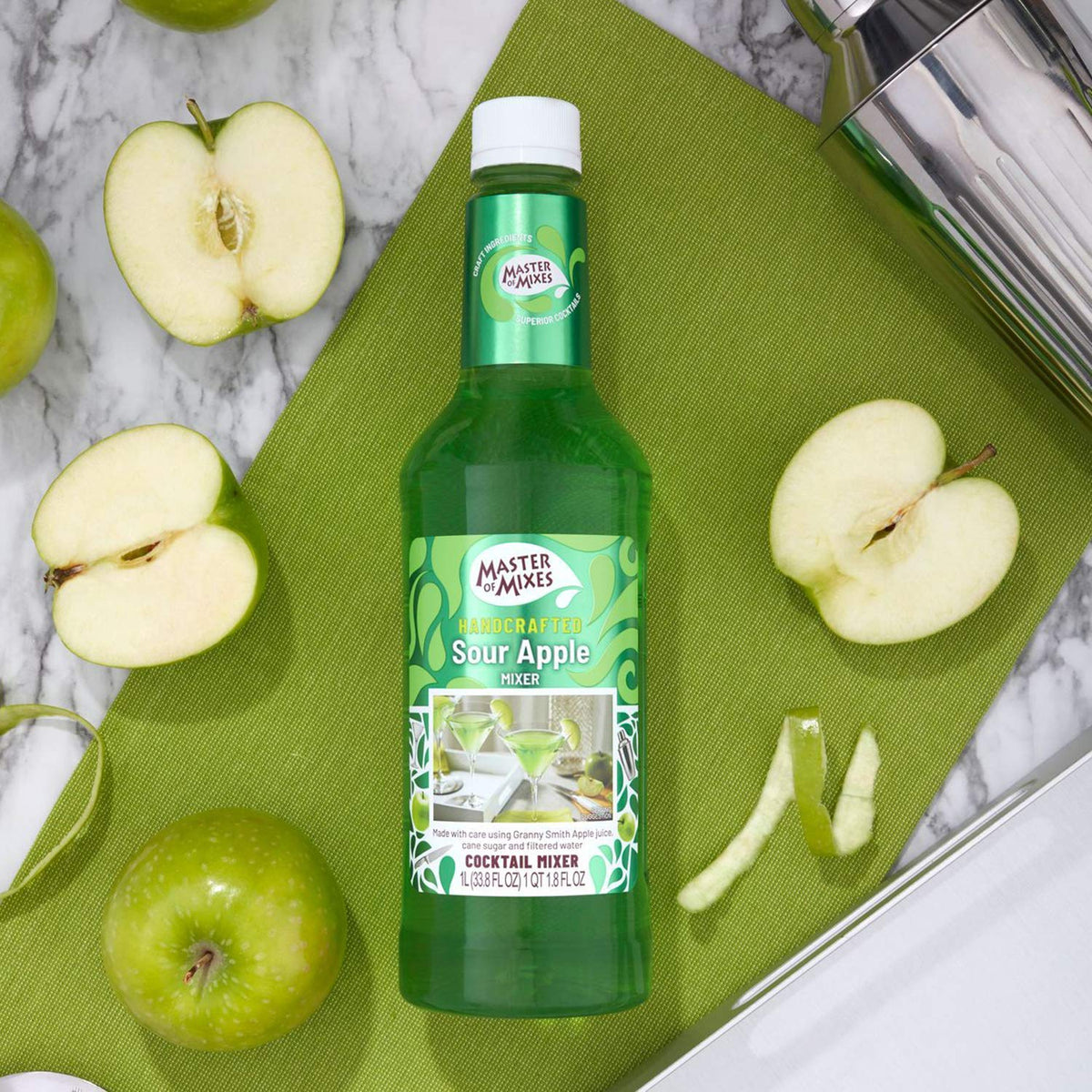 Pouring Master of Mixes Sour Apple Martini into a glass for easy mixing.