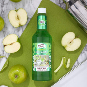 Pouring Master of Mixes Sour Apple Martini into a glass for easy mixing.
